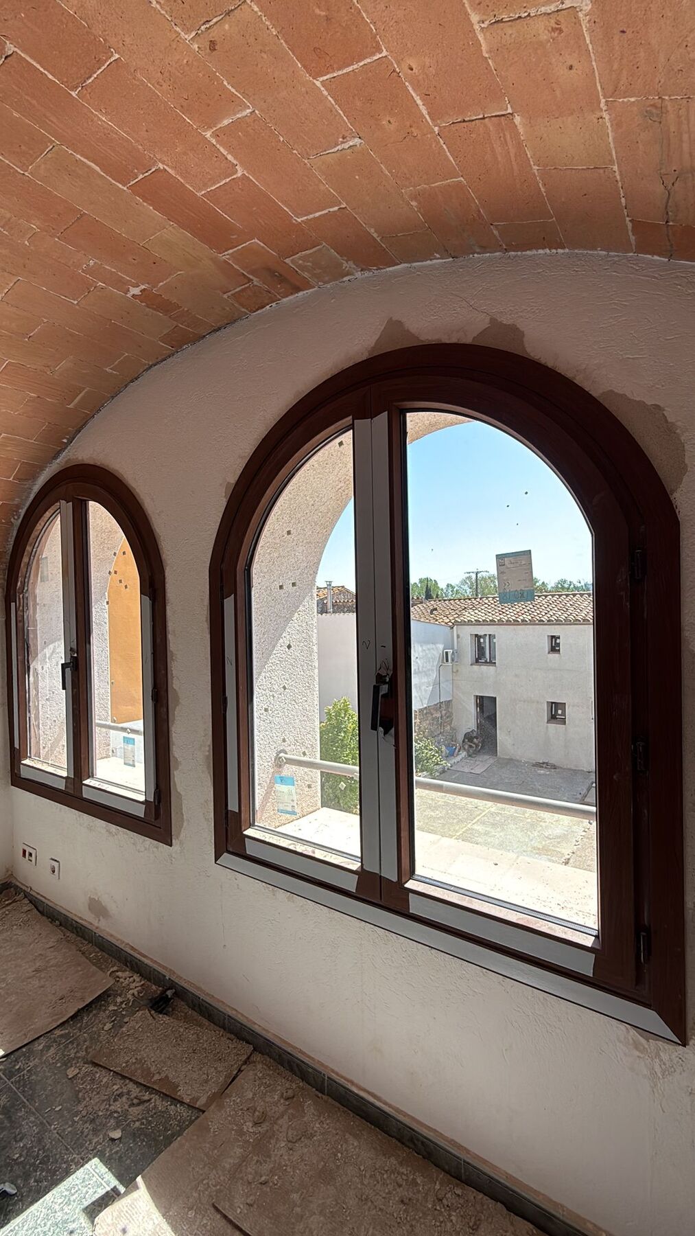 Ventanas de aluminio en arco instaladas bajo un techo abovedado de ladrillo