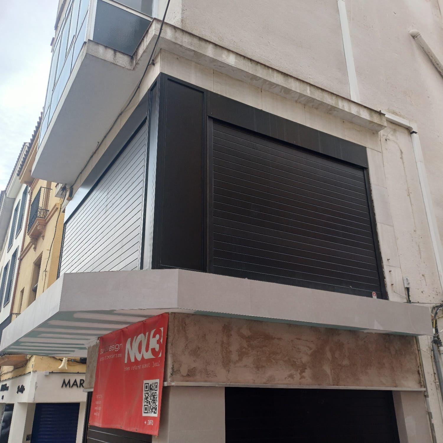 Persiana enrollable de aluminio oscura en la esquina de un edificio