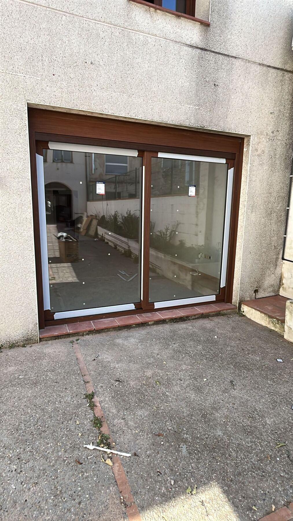 Puerta corredera de aluminio en tono madera vista desde el patio exterior