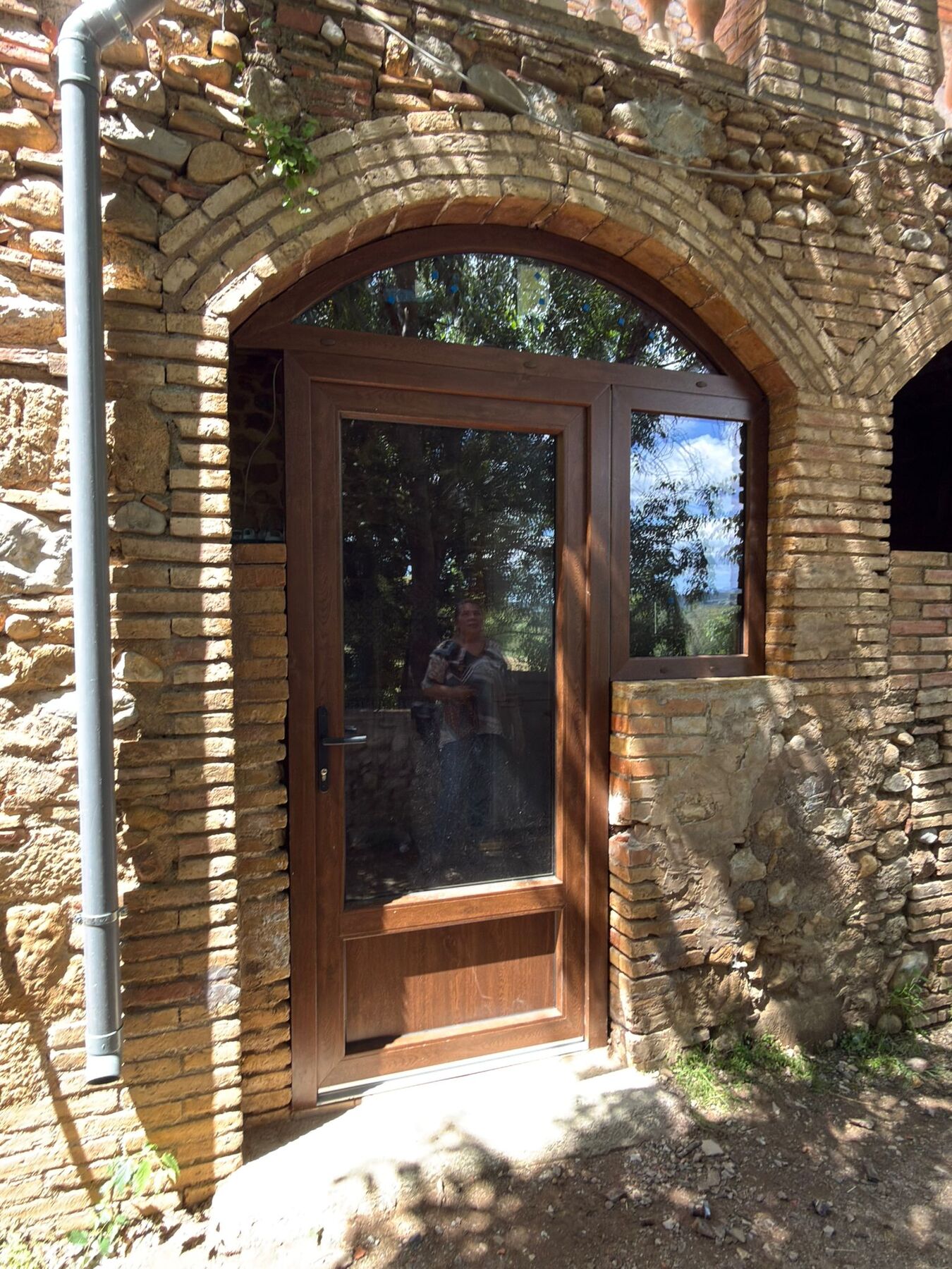 Puerta acristalada de aluminio en un arco de piedra