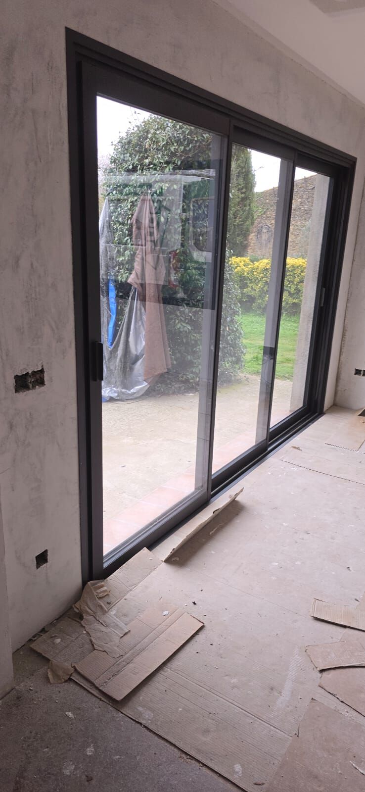 Puerta corredera de aluminio negra de gran altura con salida al exterior